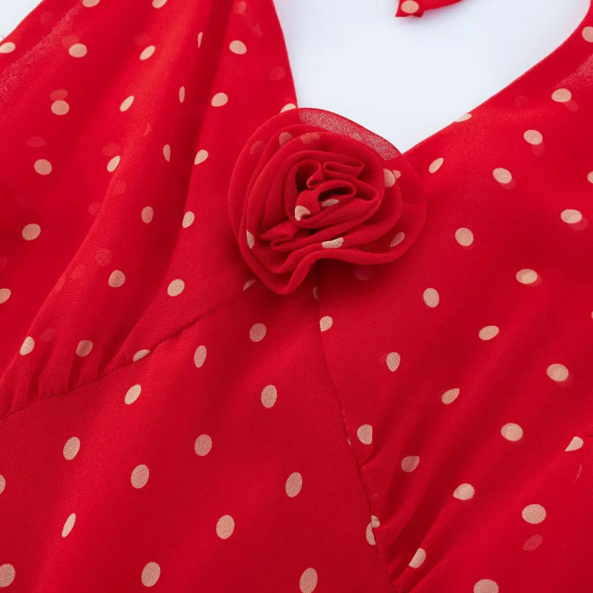 Close-up of matching red invisible side zipper on polka dot chiffon midi dress.