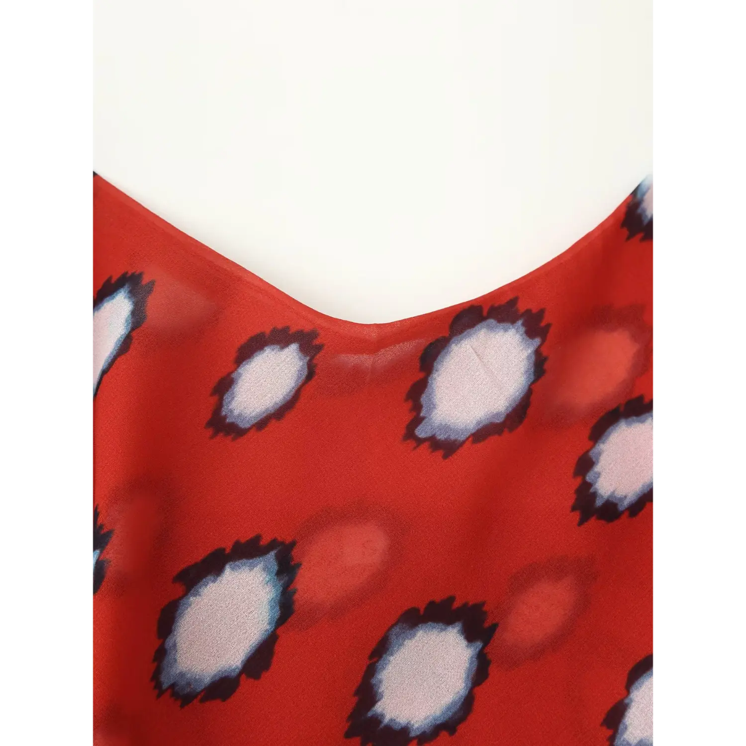 Closeup of V-neck stitching on red polka dot chiffon midi dress