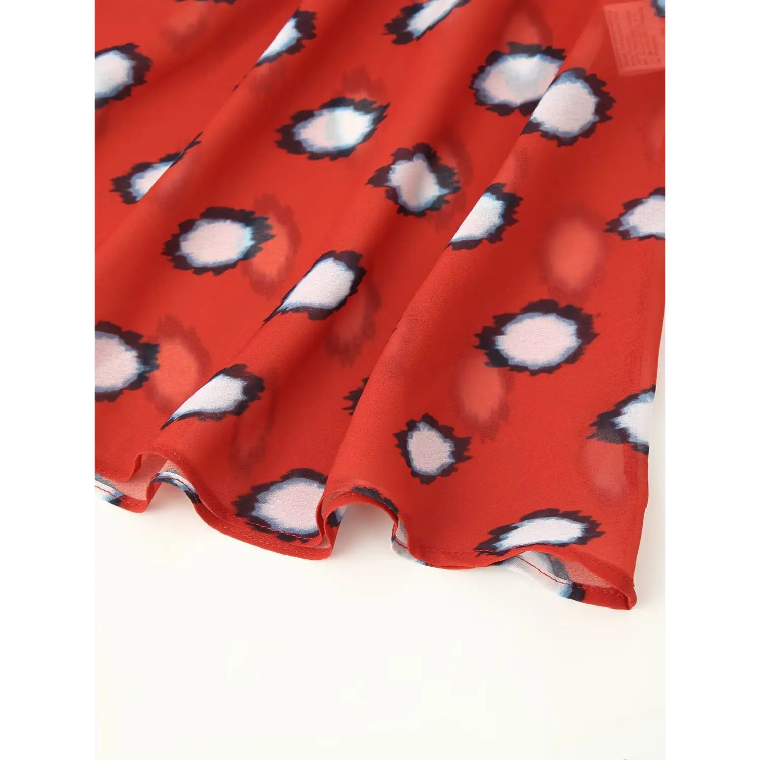 Scalloped mermaid hem detail of red polka dot chiffon midi dress