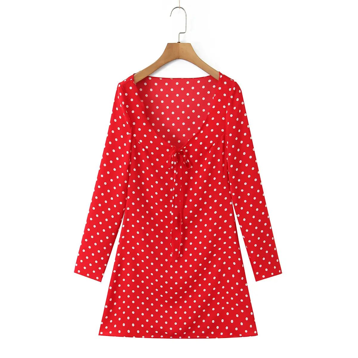 Full front view of the red polka dot mini dress on a wooden hanger.