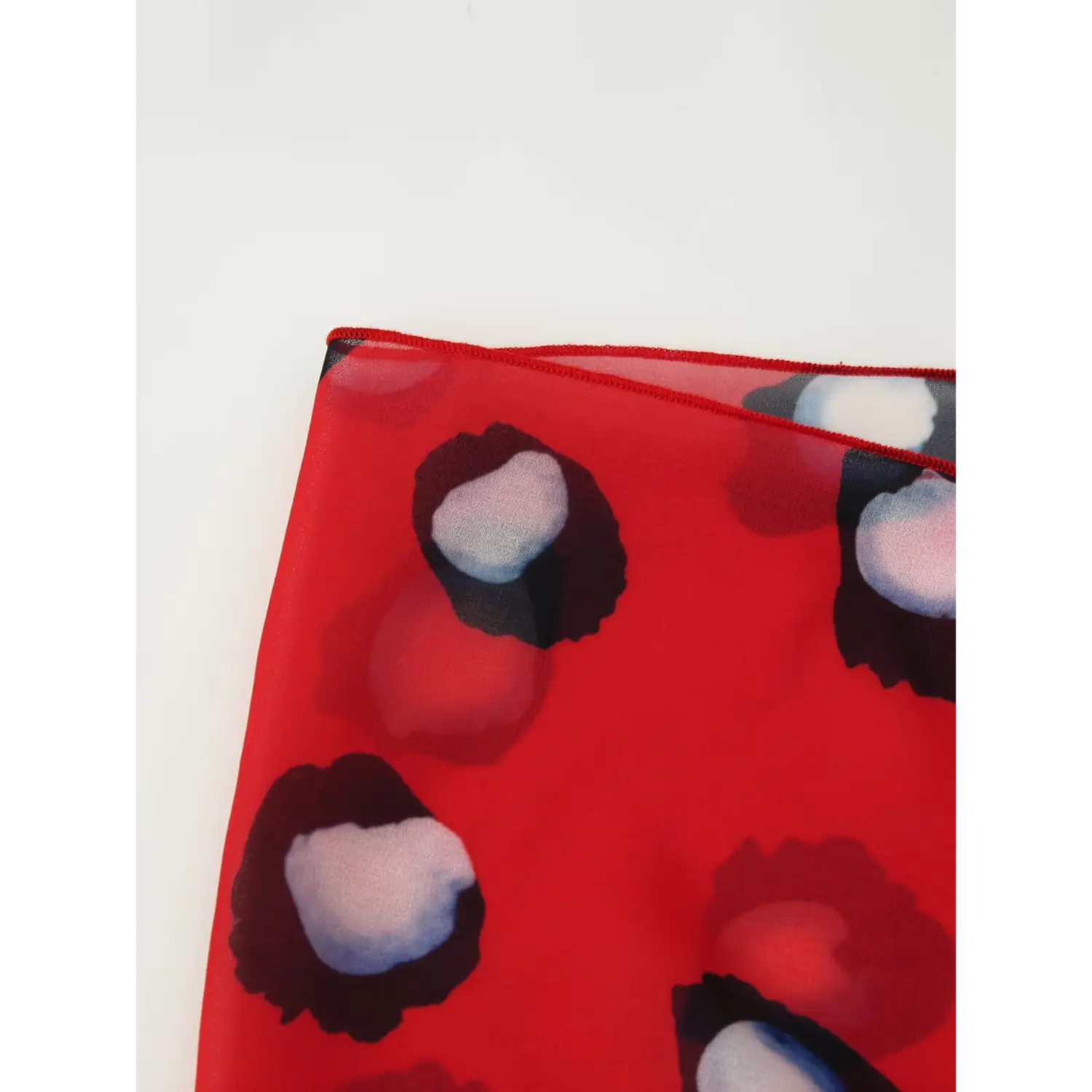 Neat overlock hem stitching close up of red printed chiffon wrap tie panel for collared blouse