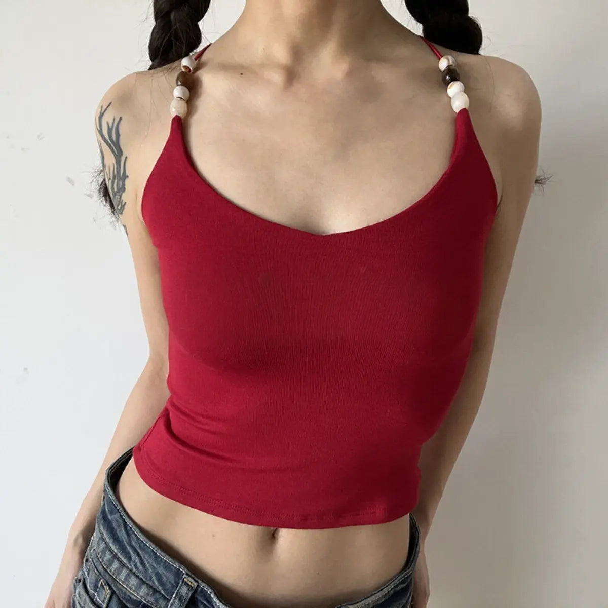 Lifestyle shot of red ribbed camisole with beaded straps and crisscross back