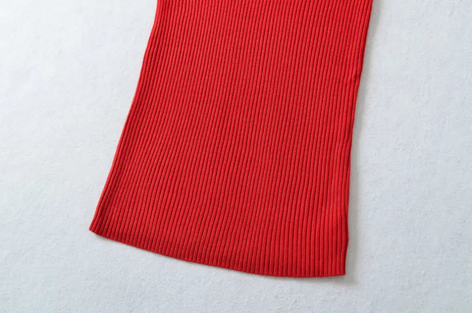 Detail shot of vertical ribbed skirt hem on red bodycon knit midi dress