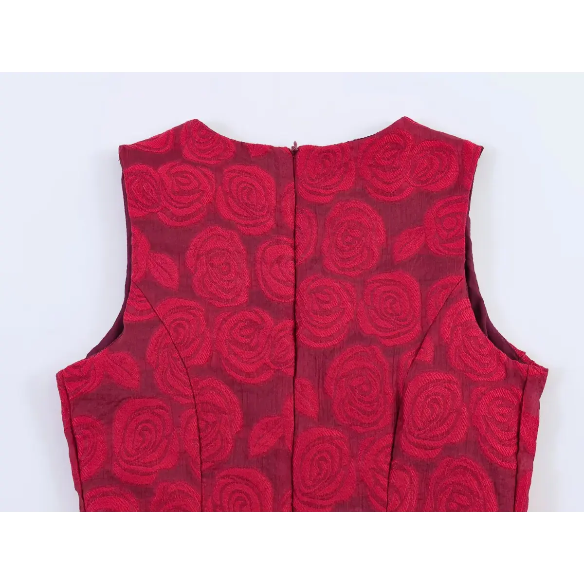Back view of a red rose brocade sleeveless dress, showing the center-back zipper and structured bodice seams.
