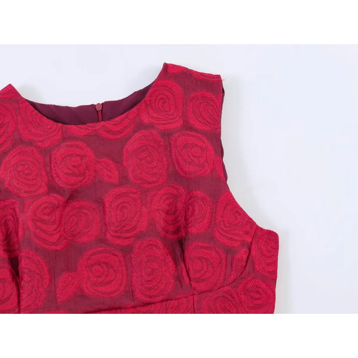 Close-up of the round neckline, shoulder seam, and center-back zipper on a red rose brocade dress.
