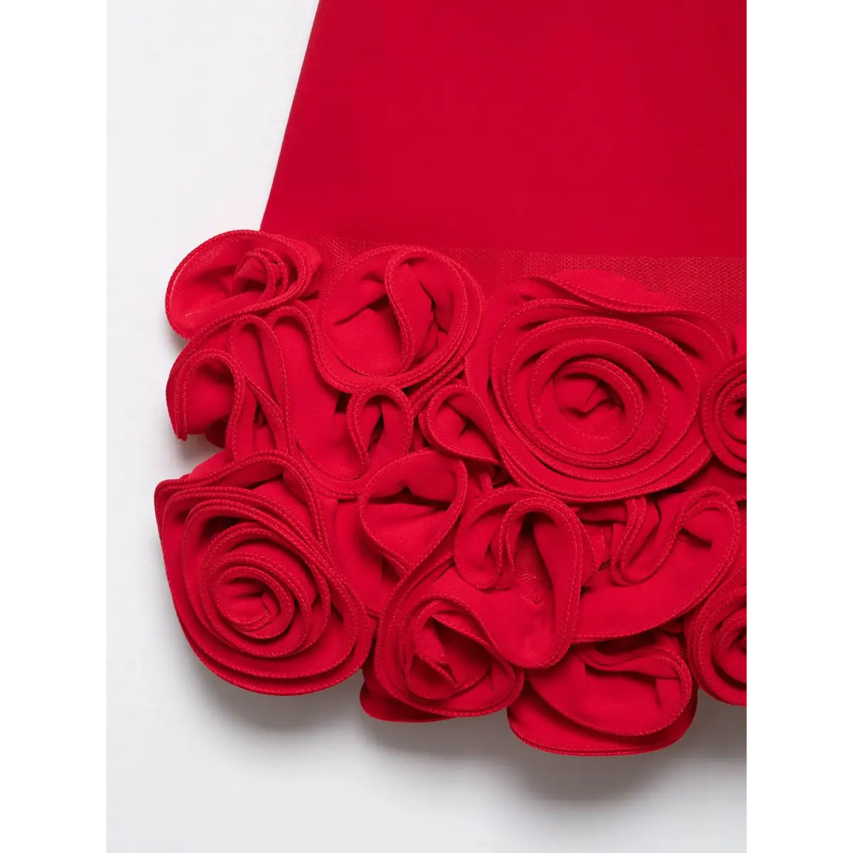 Close-up of the dress's hem, highlighting the texture and detail of the 3D rose appliqués.