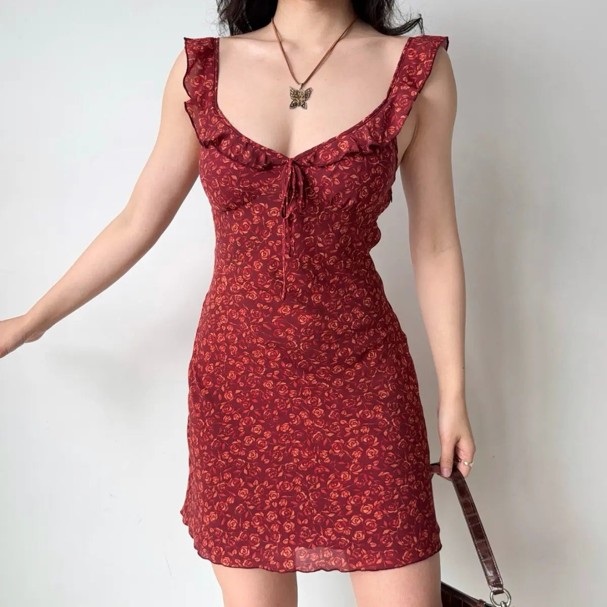 Side view of the red rose print mini dress, showing the fit and flared hem.