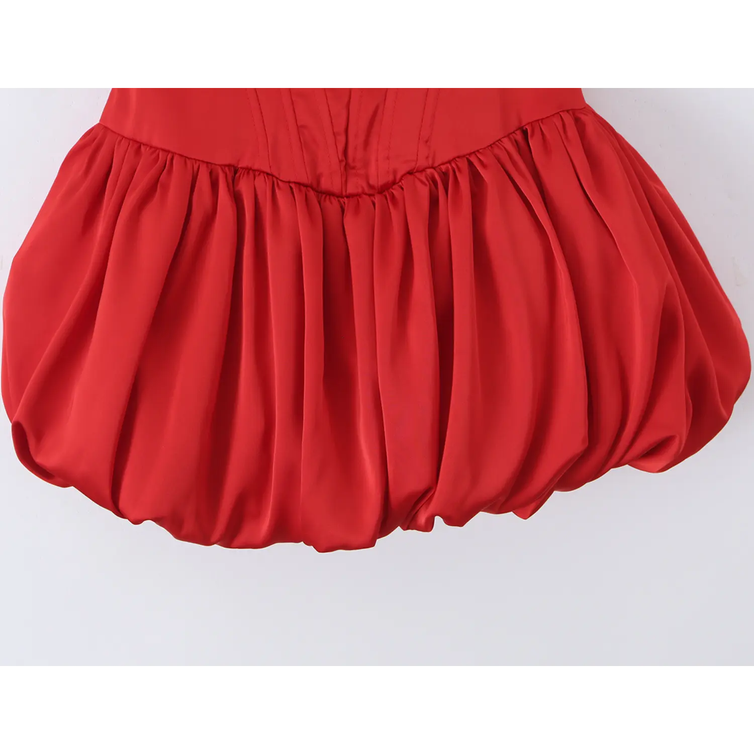 Close-up shot of rounded bubble puffy hem with gathered satin fabric for voluminous balloon skirt silhouette
