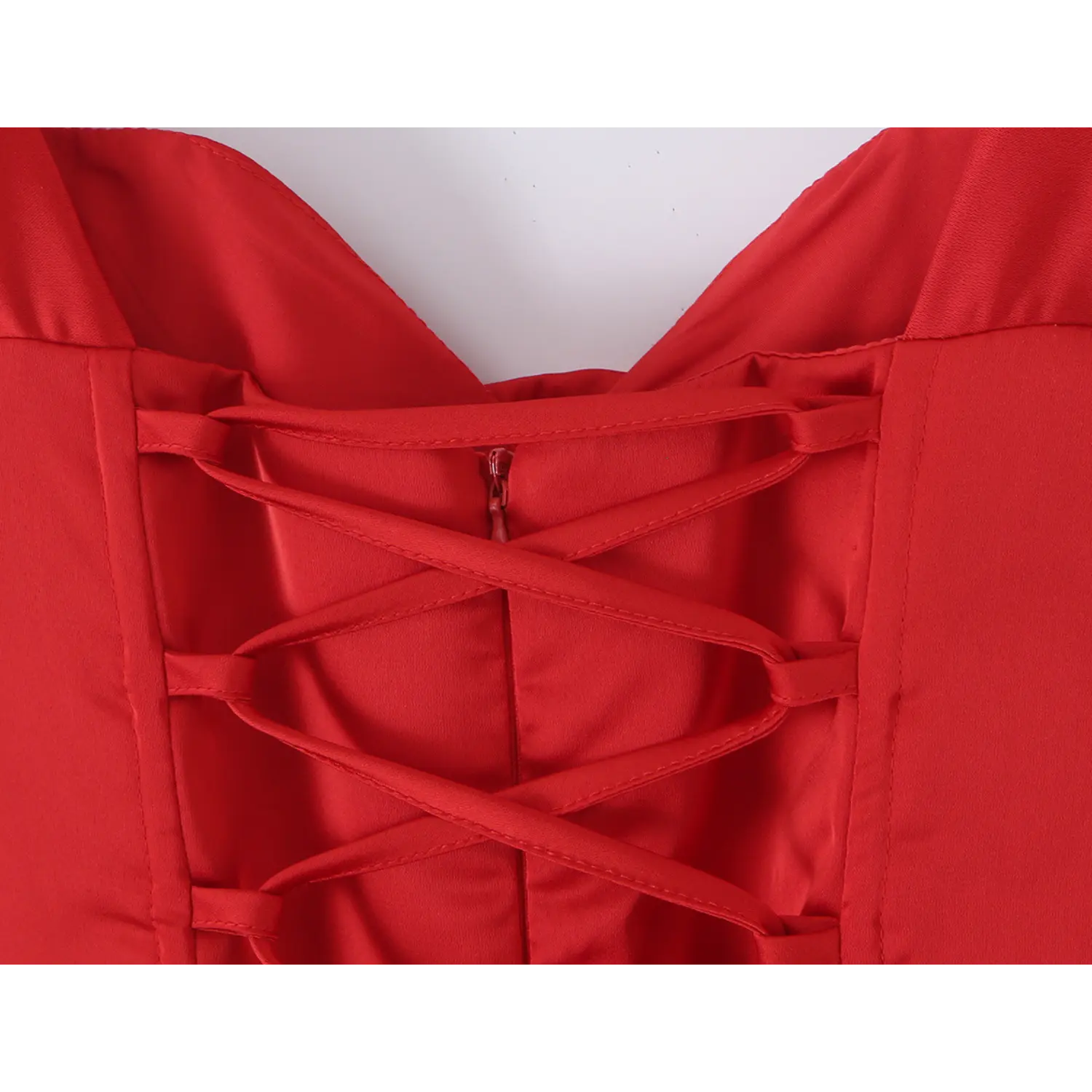 Macro close up of criss cross adjustable lace up ribbon closure on red satin corset dress back