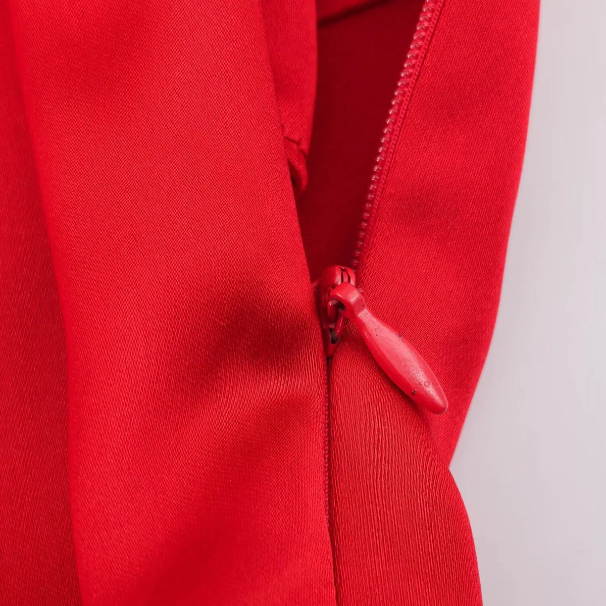 Close-up of back zipper on red satin dress