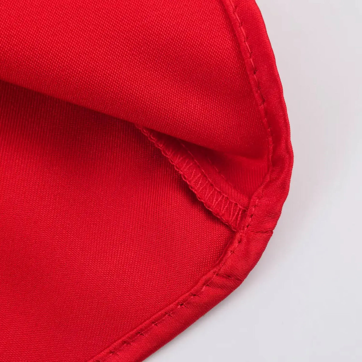 Close-up of finished hem stitching on red satin fabric