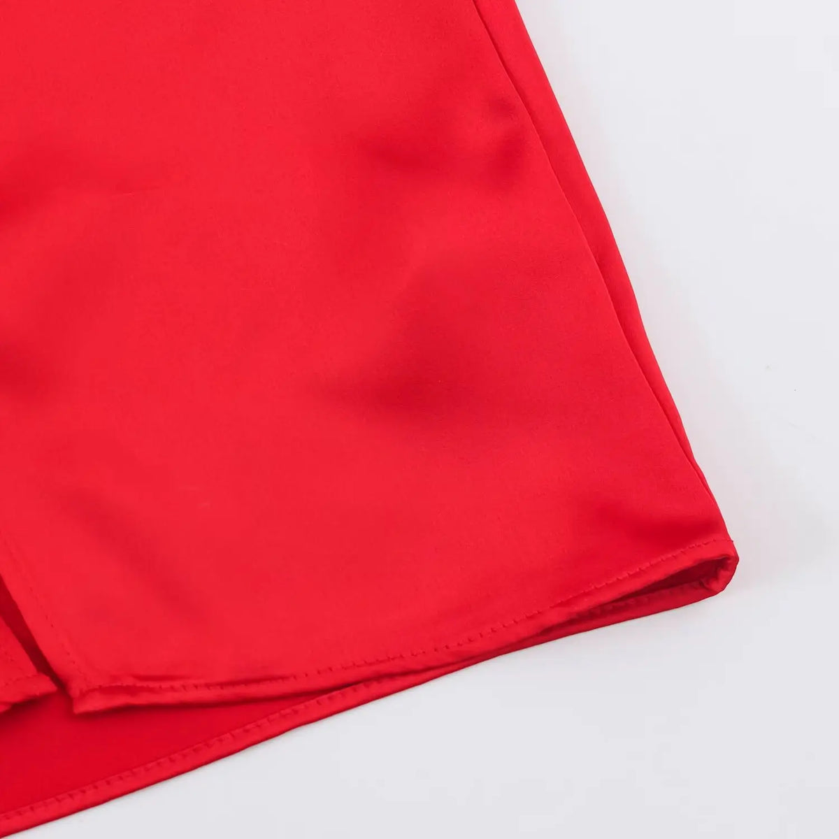 Close-up of skirt corner and hem on red satin dress