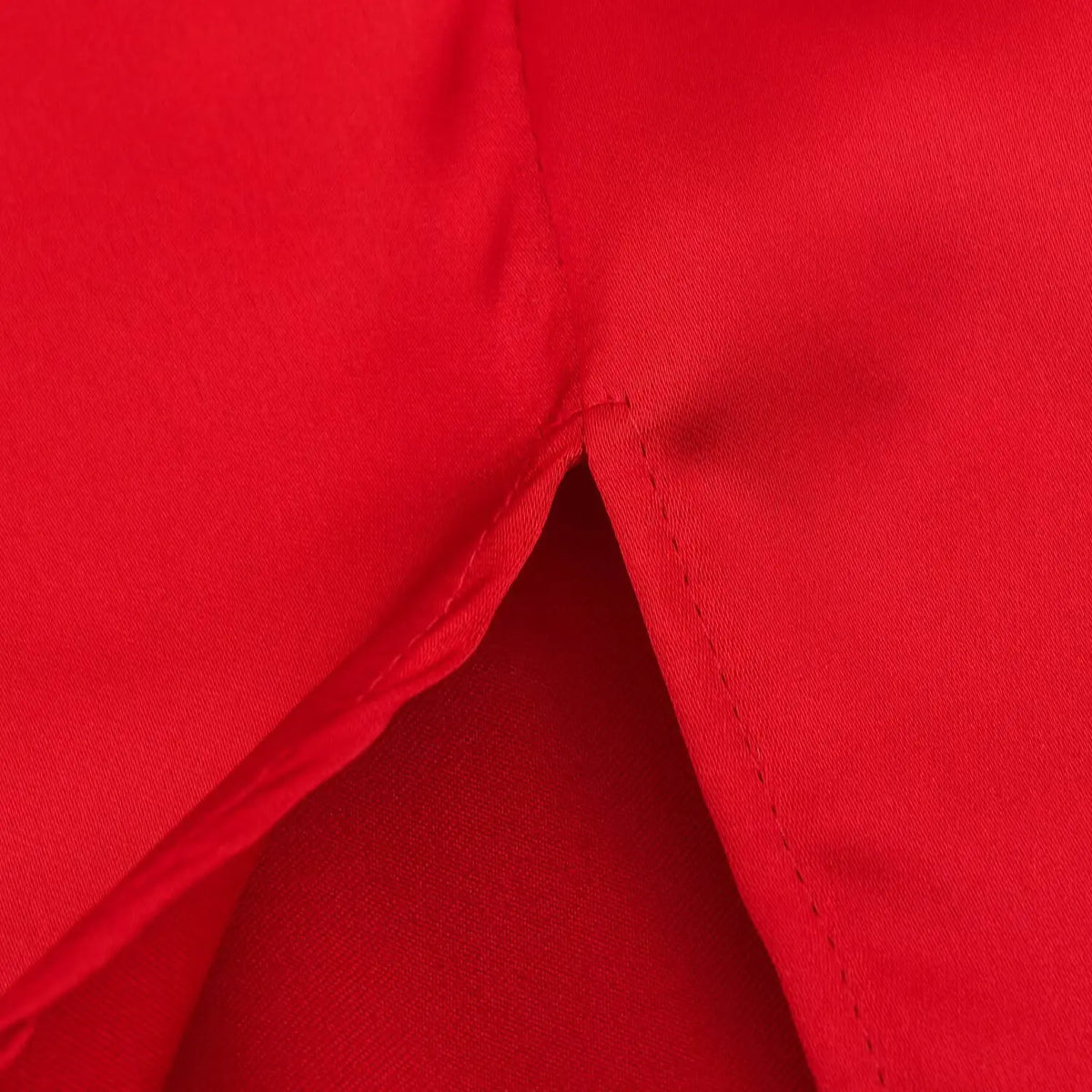 Close-up of side slit stitching on red satin dress