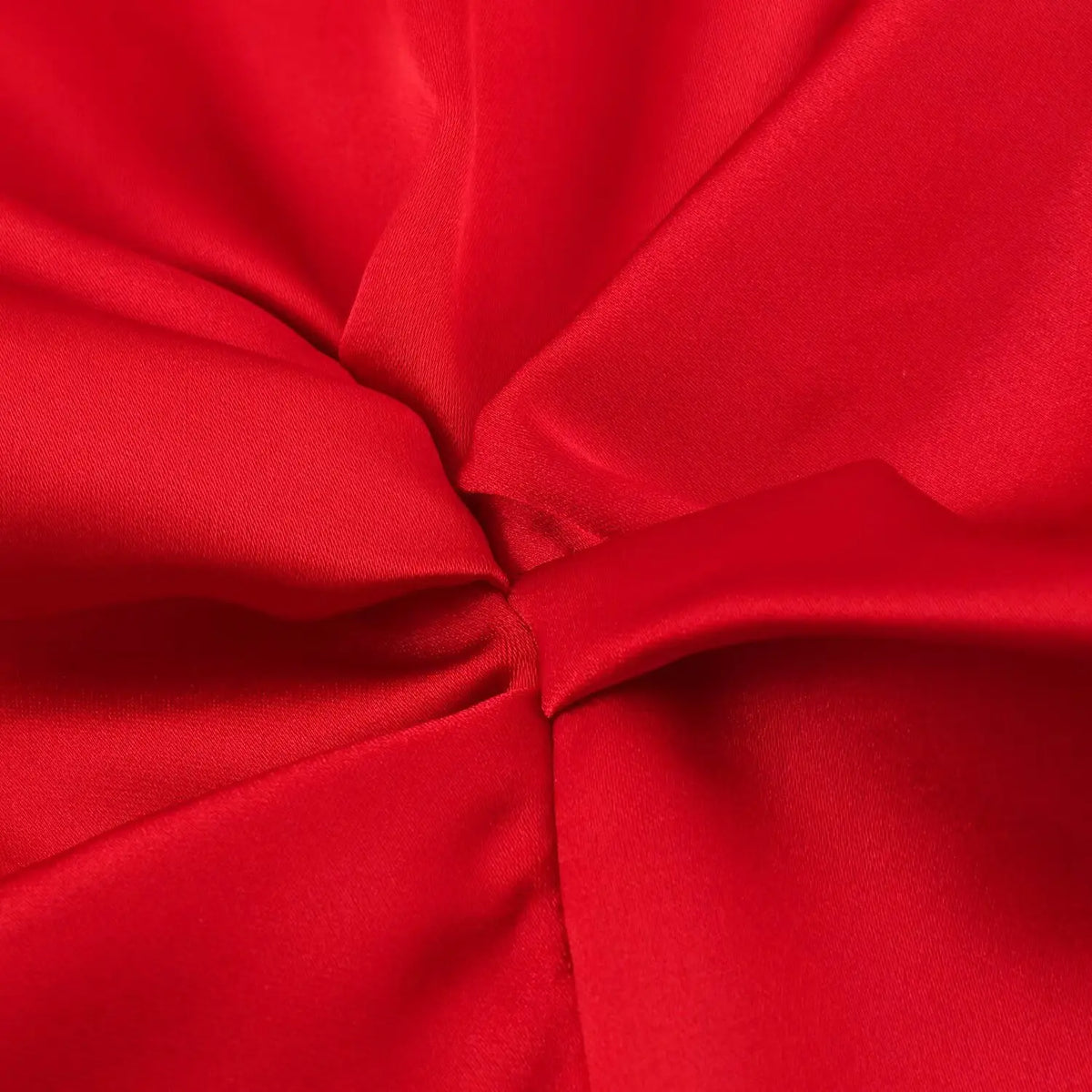 Close-up of twisted knot detail at waist on red satin dress