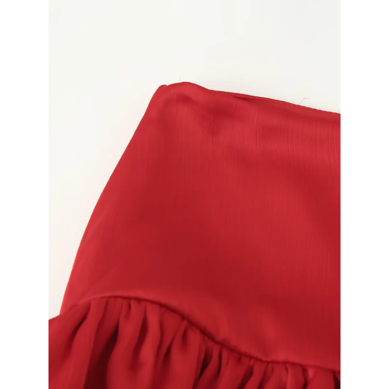 Macro close up of textured red satin waist fabric for ruffled chiffon maxi skirt