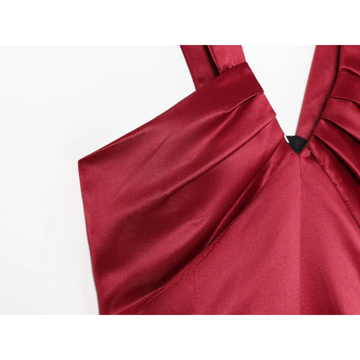 Close-up view of the gathered bust on a red satin mini dress, showing the pleated fabric and wide strap construction.
