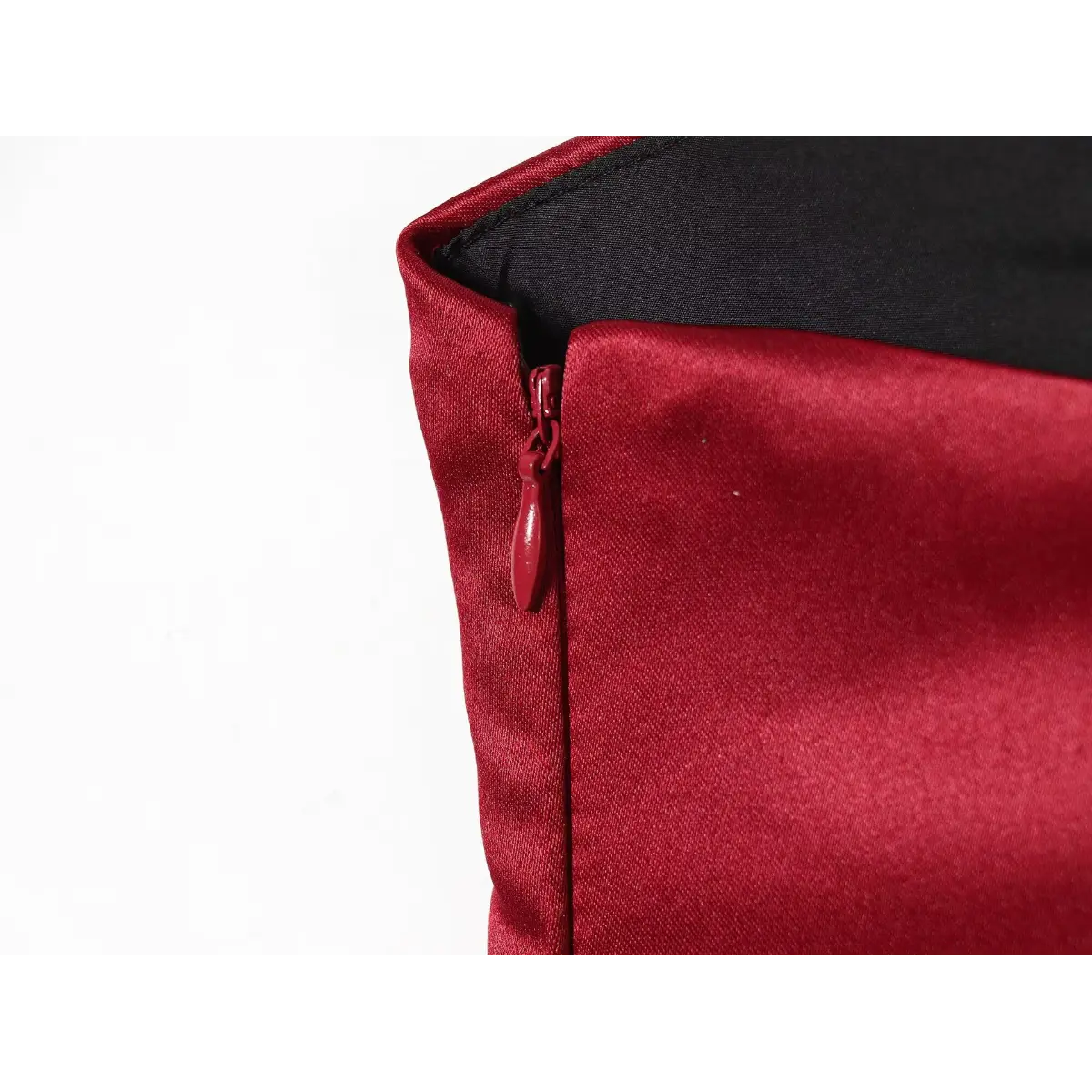Close-up detail shot of the side zipper on a red satin mini dress, showing the red zipper pull and black lining.