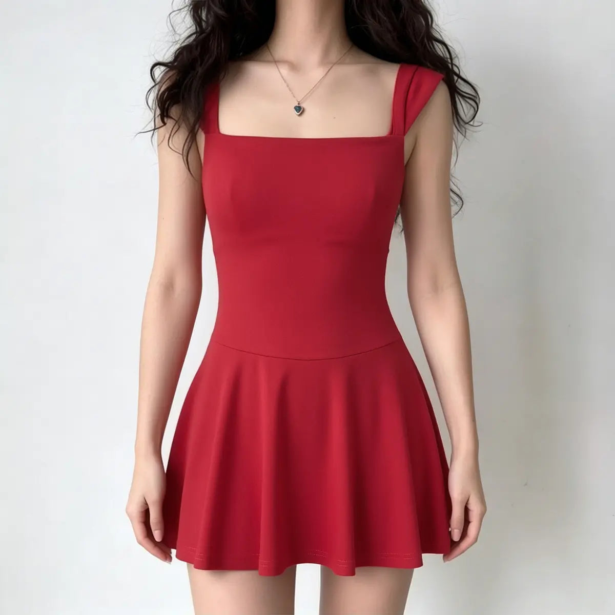 Full-body shot of a woman wearing a bright red sleeveless fit-and-flare mini dress with a square neckline.