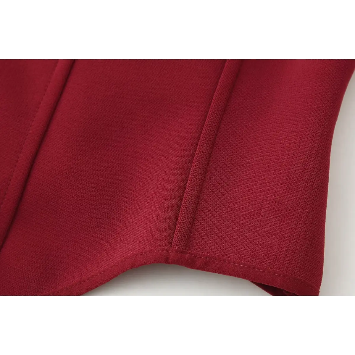 Close-up of the vertical boning seams on the red bustier cami top, showing the structured stitching and smooth knit fabric