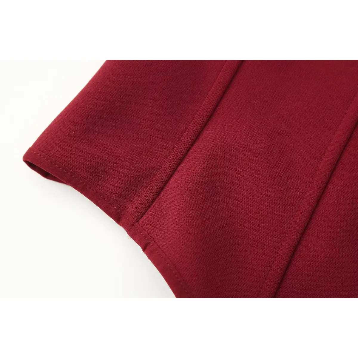 Close-up of the side boning seam on the red bustier cami top, showing the precise stitching and smooth knit texture