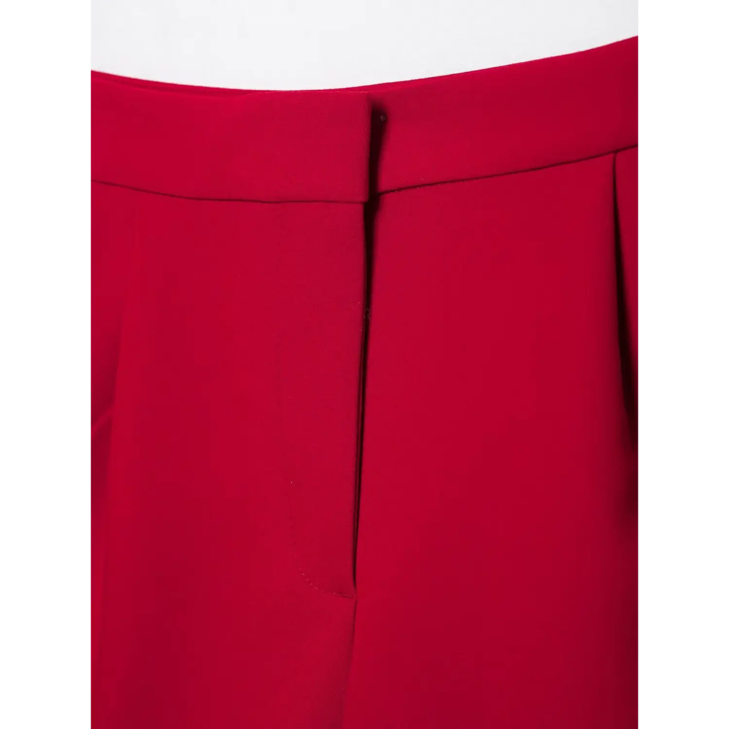 Close‑up front fly of red tailored shorts, folded waistband, fly seam detail, smooth red suiting material, white background