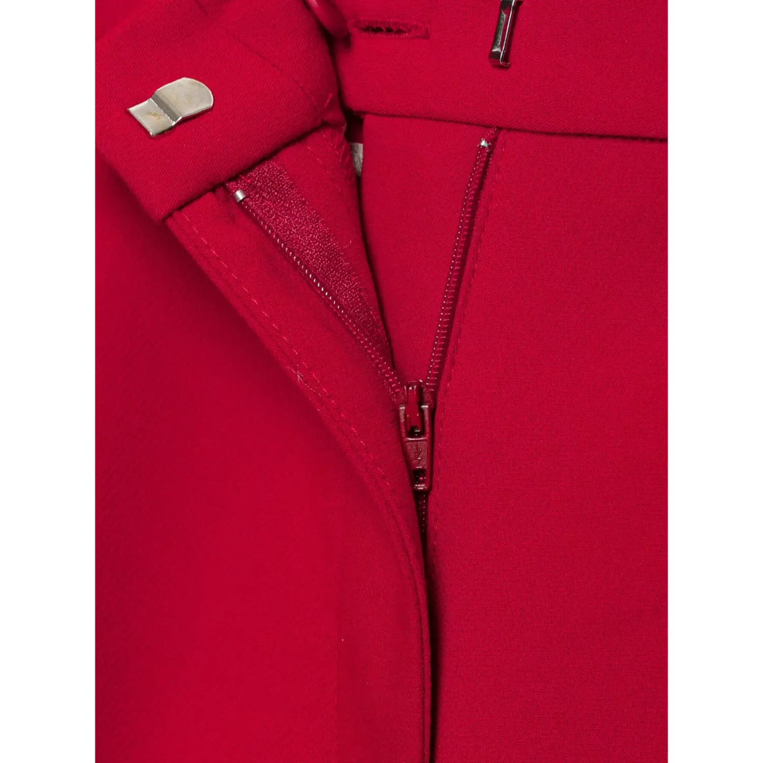 Macro close‑up inner waist closure of red suit shorts, metal hook bar, red zipper, inner stitching detail, white background