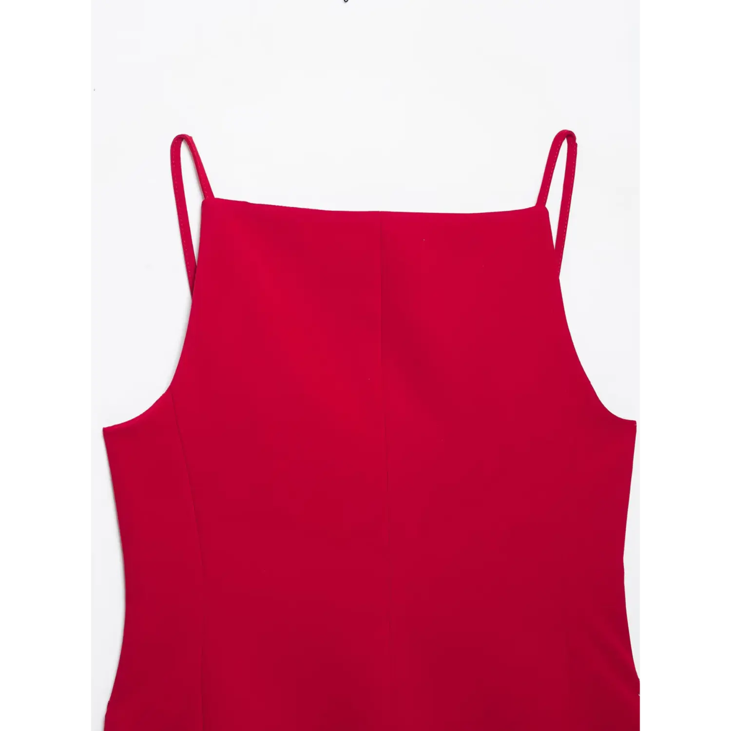 Close‑up back panel view of red cami top, straight neckline, vertical center seam, thin spaghetti straps, smooth red suiting fabric, white background