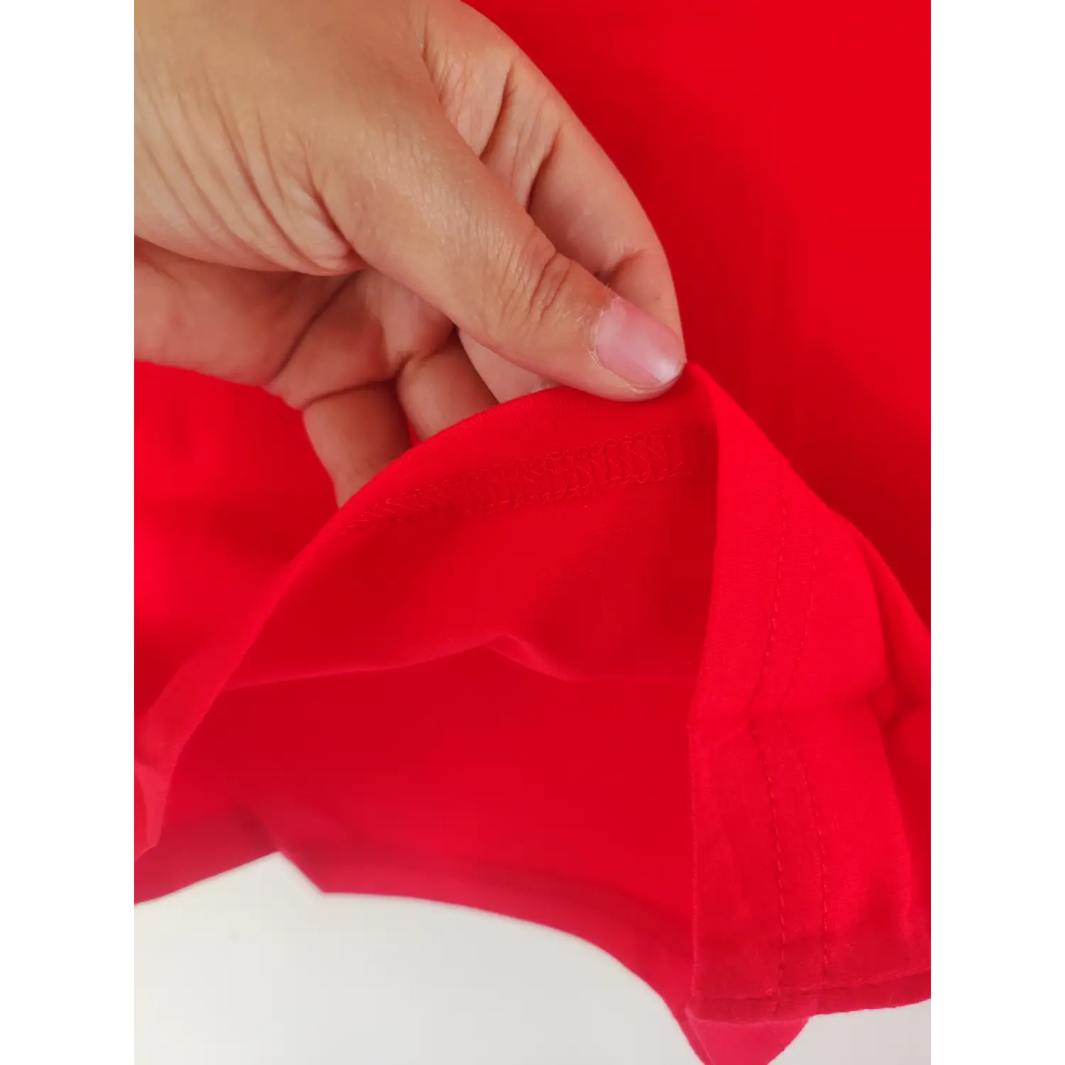 Close-up stitching detail, finished hem of red sleeveless crop top