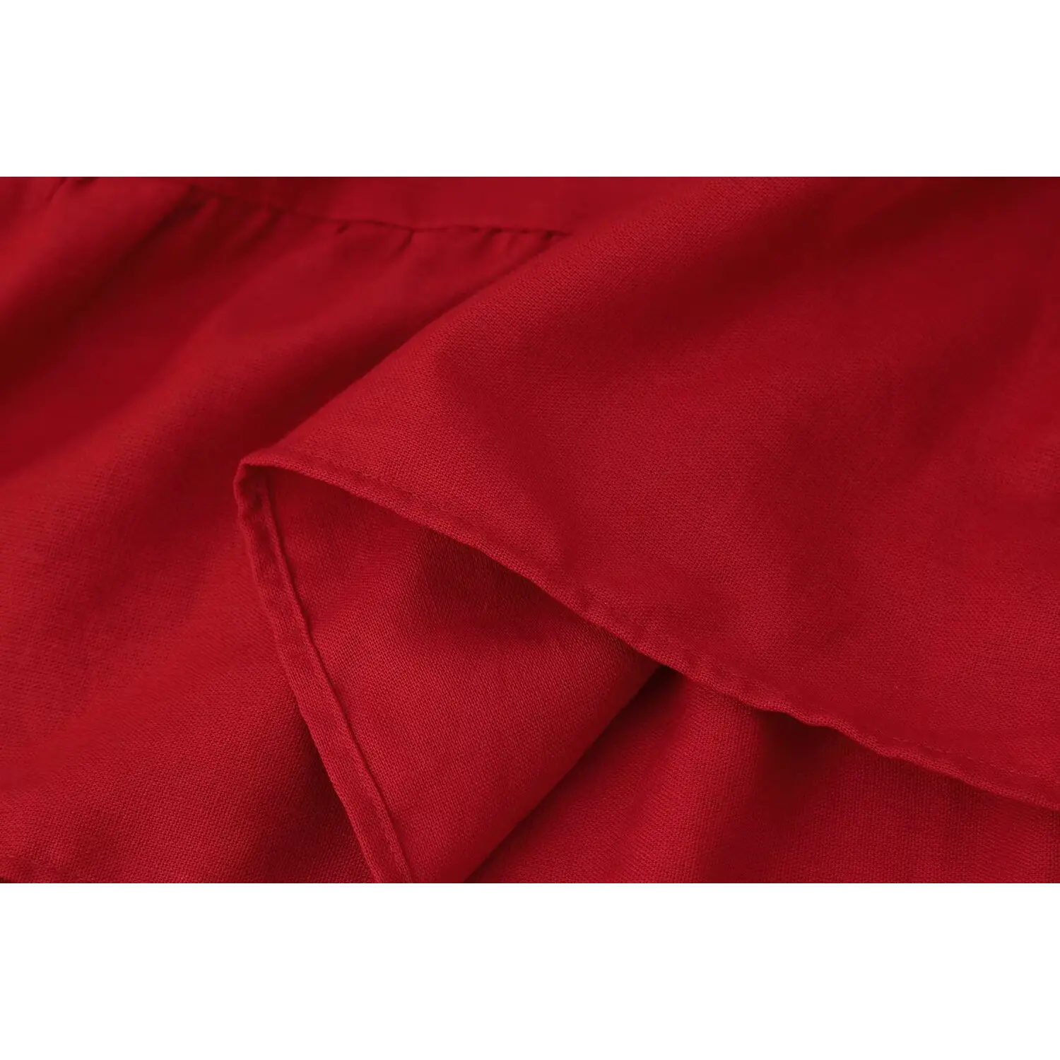 Macro close‑up of red maxi skirt lightweight woven fabric, hem stitching and layered texture detail