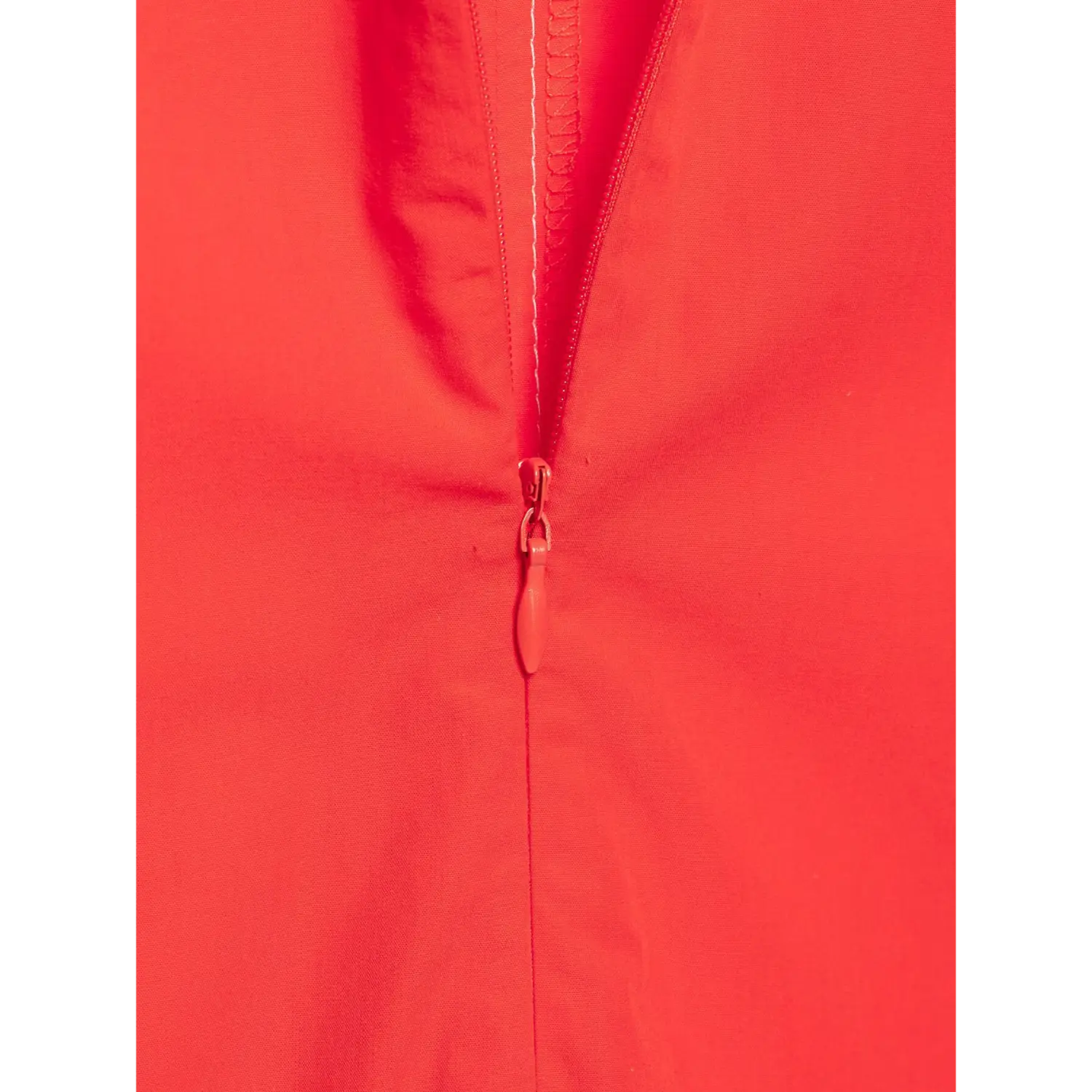 Macro shot of invisible center zipper on red fitted poplin blouse