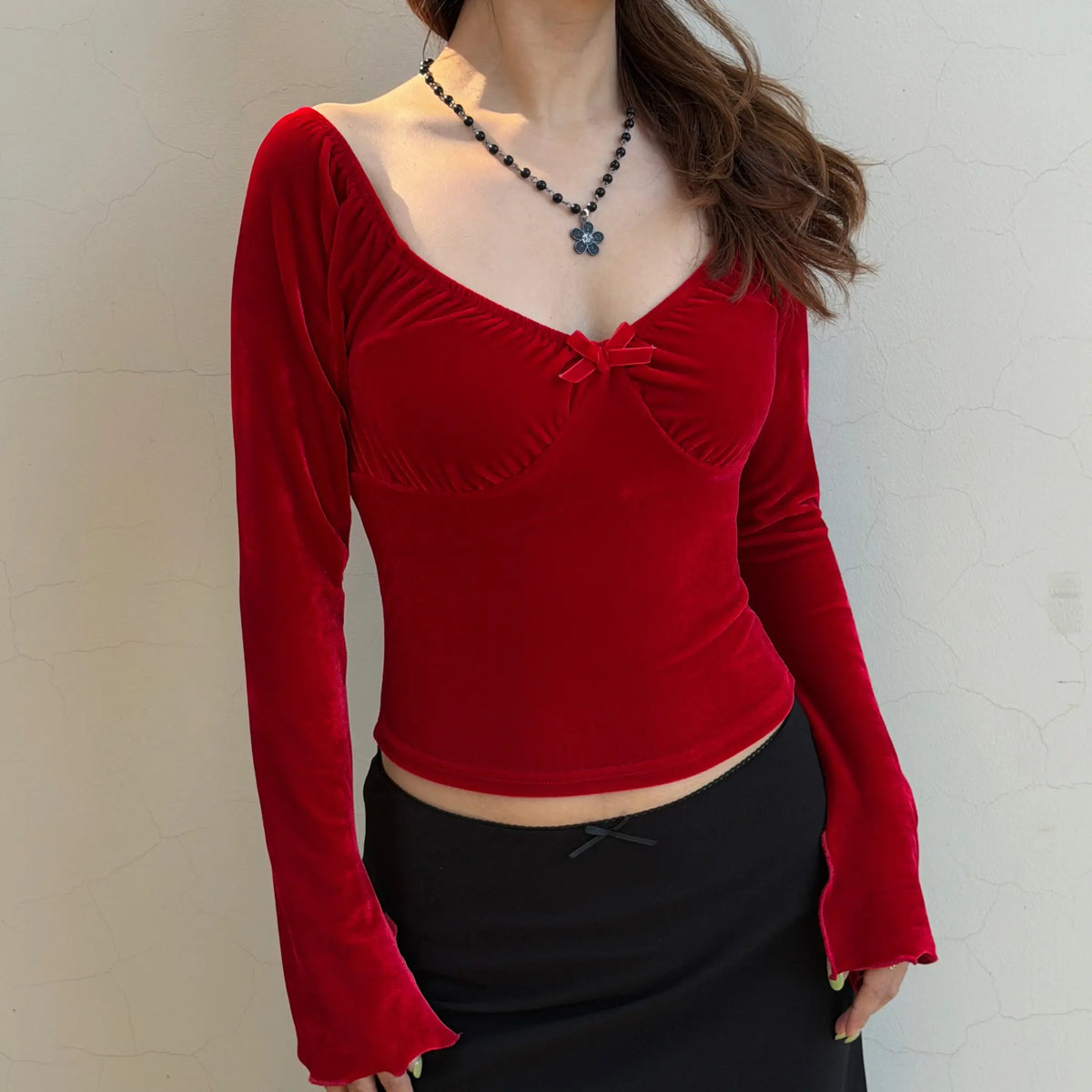 Model wearing red velvet sweetheart bow long sleeve crop top, angle view