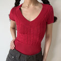 Model wearing red v‑neck cable knit short sleeve fitted sweater top front view