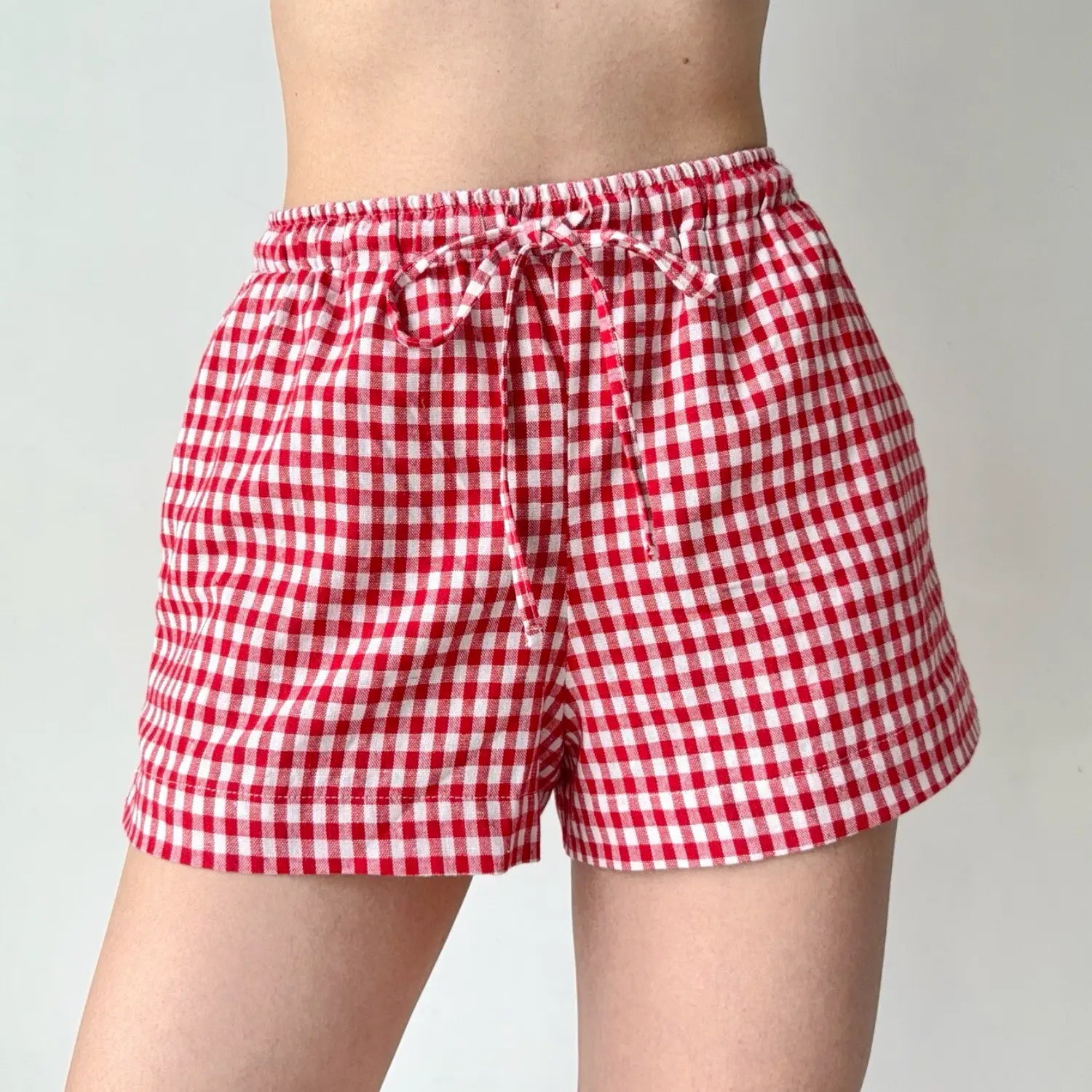 Close-up shot of red and white gingham shorts with an elastic waist and drawstring tie