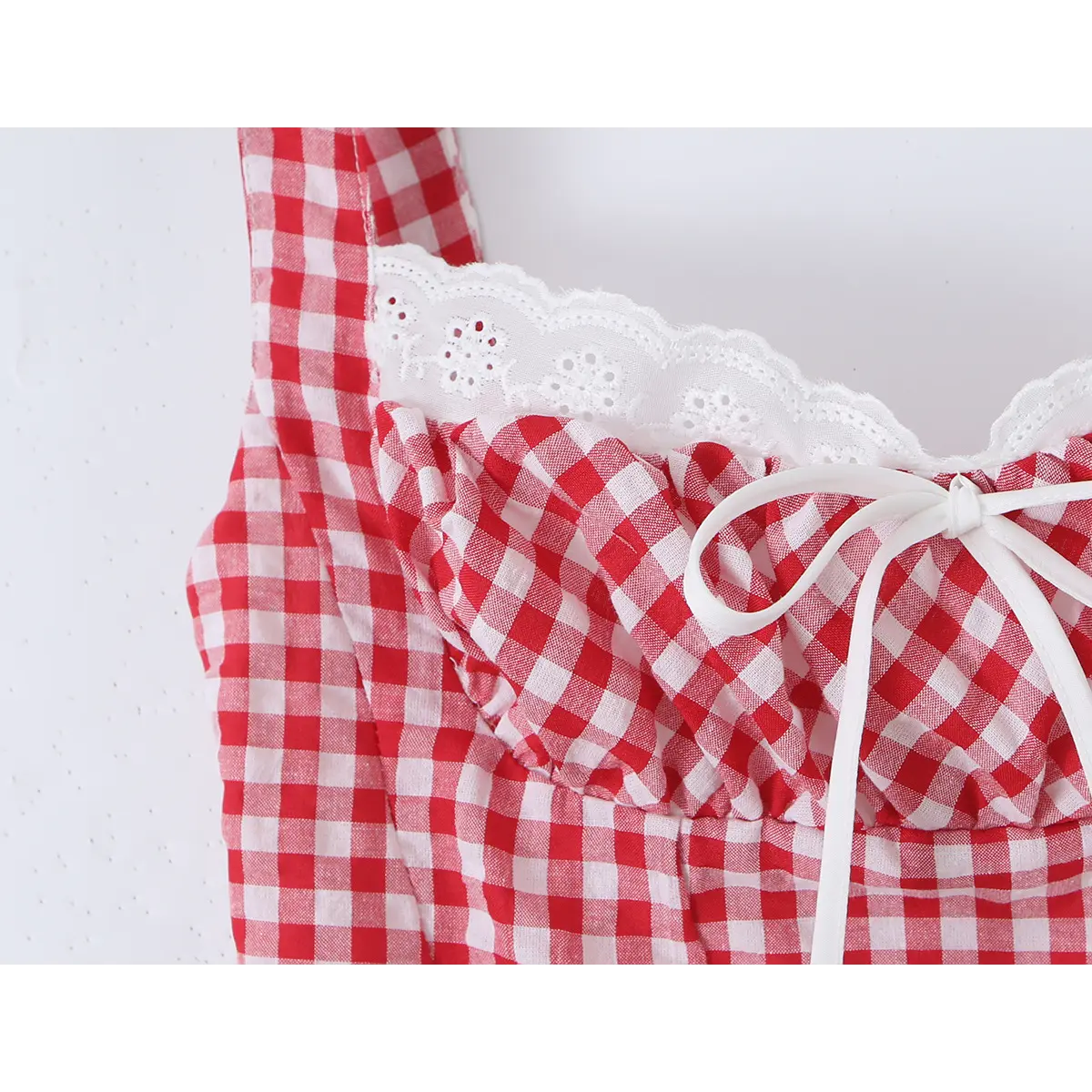 Close-up detail of the front bow and lace trim on a red and white gingham bustier tank top, showing the gathered bust and scalloped neckline.