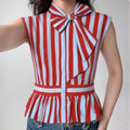 The top styled on a model, highlighting the fit, bow detail, and peplum silhouette.