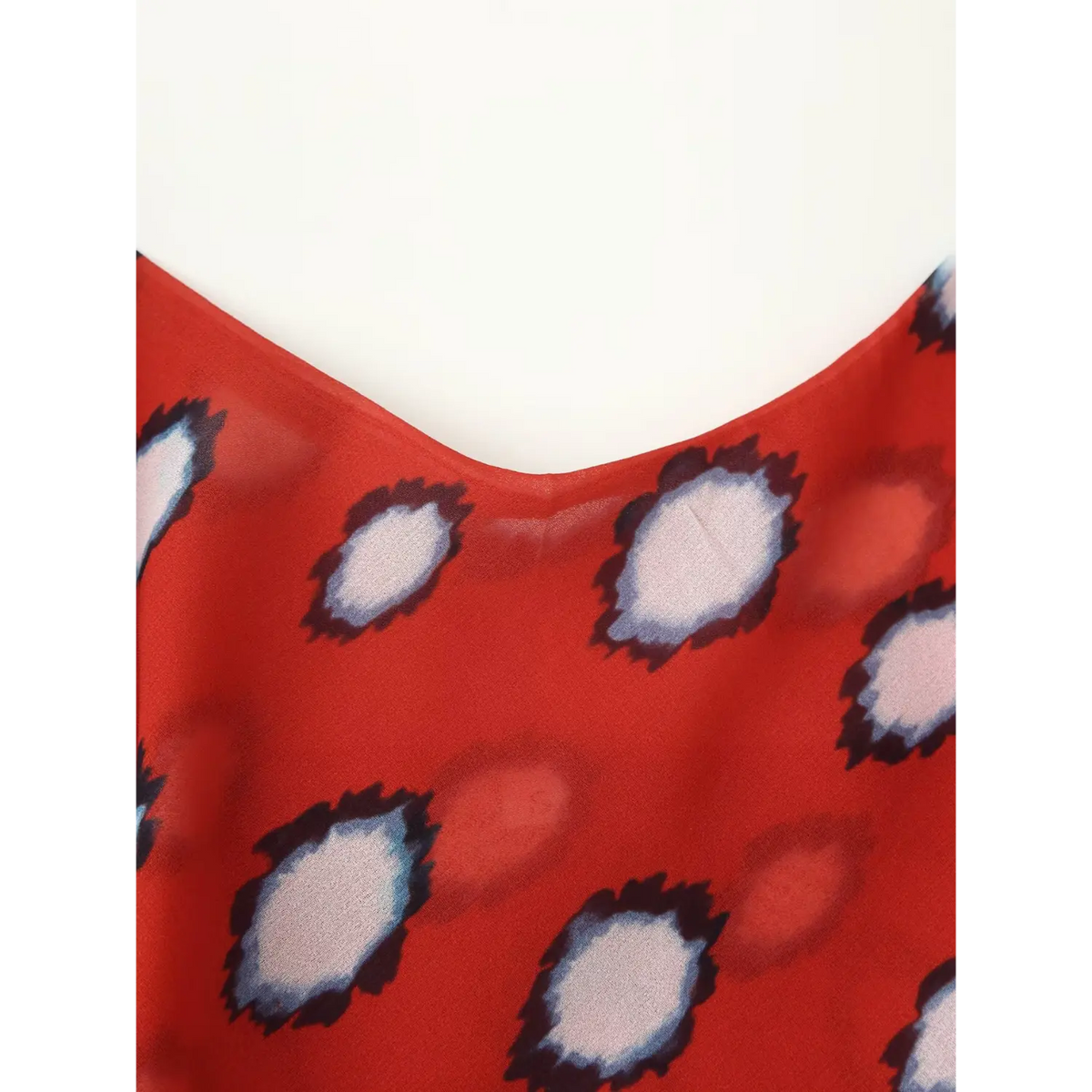 Close‑up of v‑neckline on red abstract dot print maxi dress