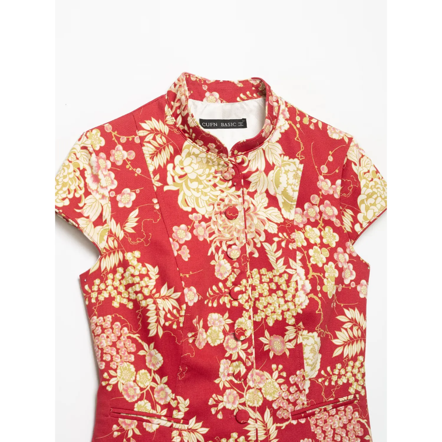 Flat lay upper shot of red floral jacket, mandarin stand collar, full fabric‑covered button placket and cap sleeves