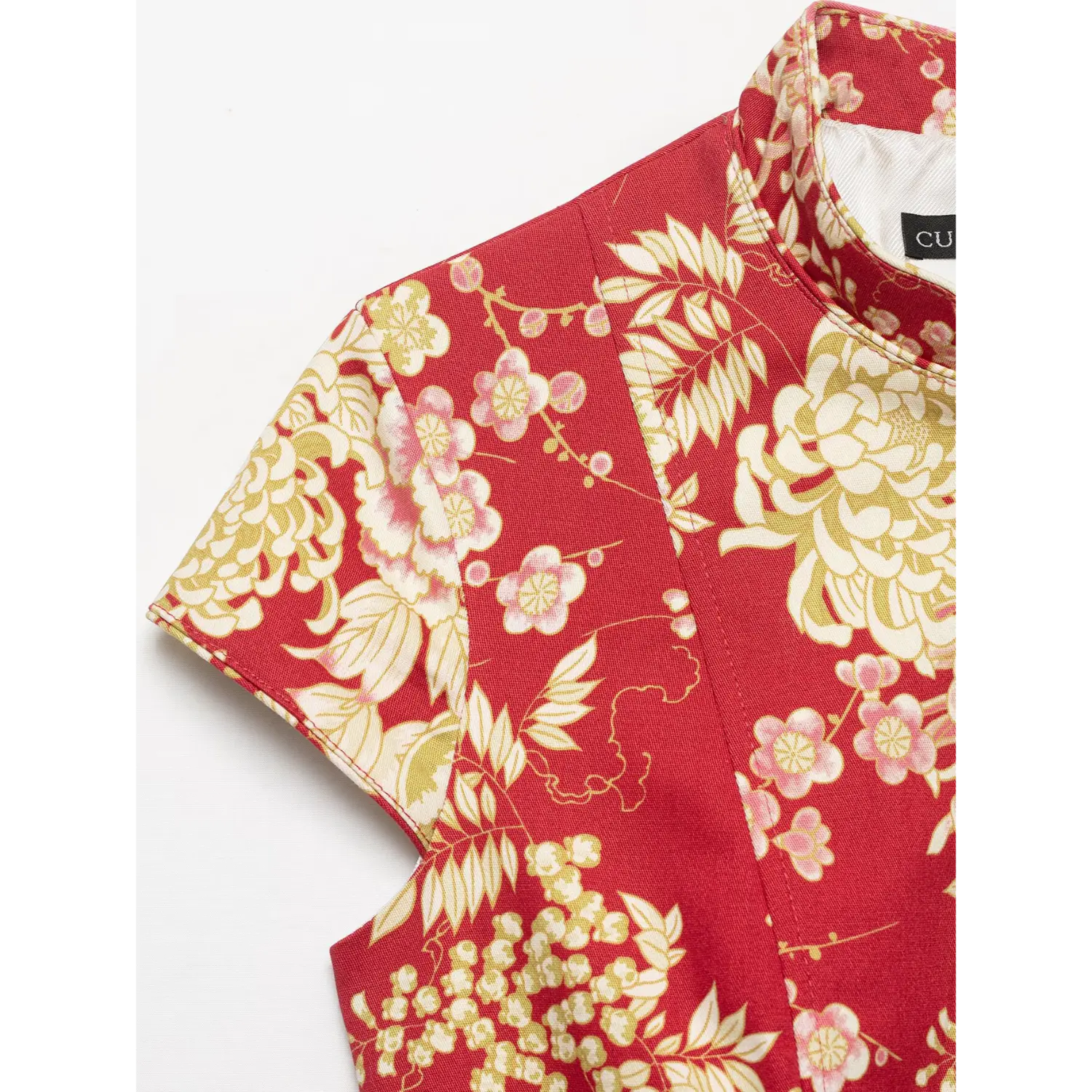 Close‑up shot showing shoulder, mandarin stand collar and rich red chinese floral print fabric texture