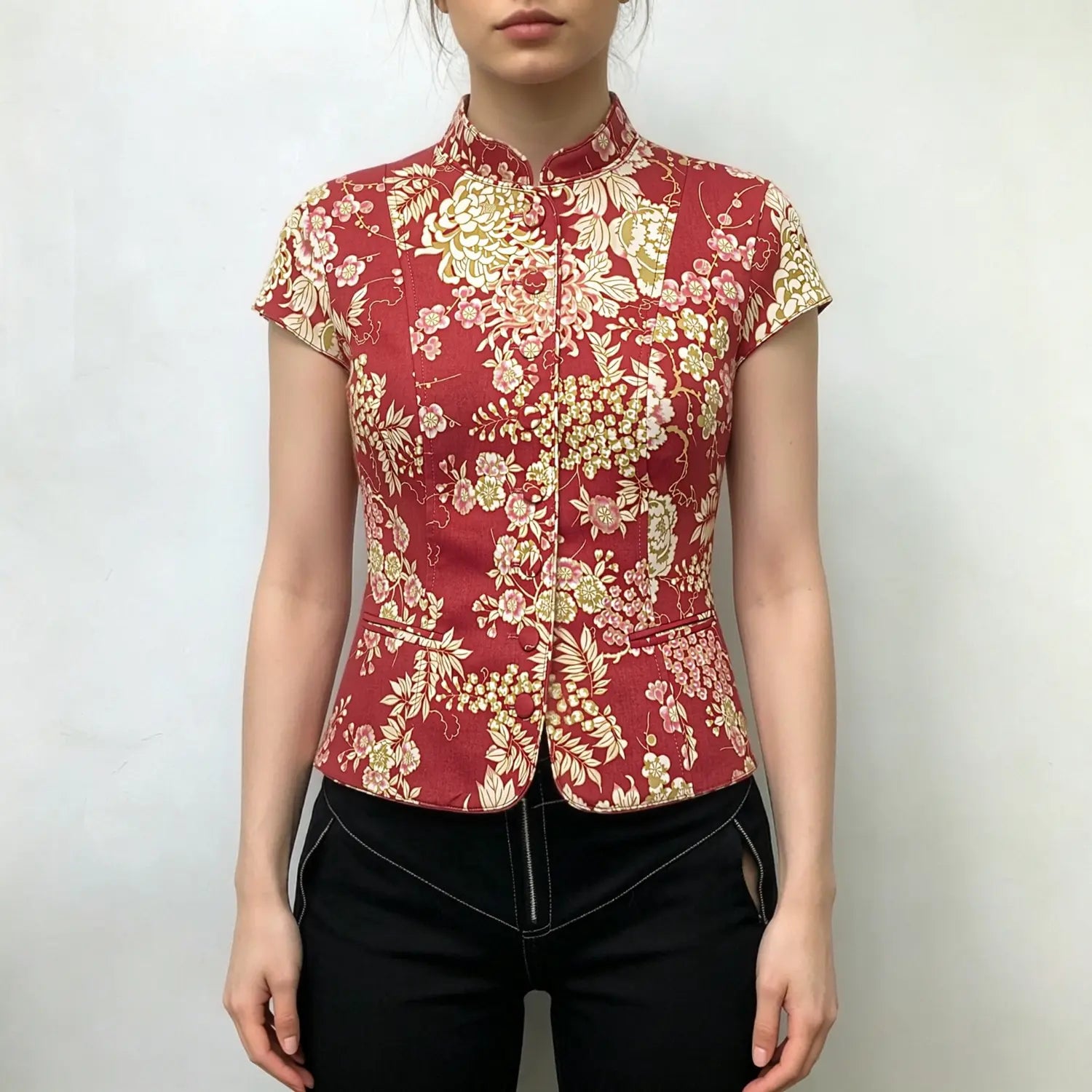 Model wearing red chinese floral print cap‑sleeve mandarin collar fitted jacket, styled with black pants, front lifestyle shot