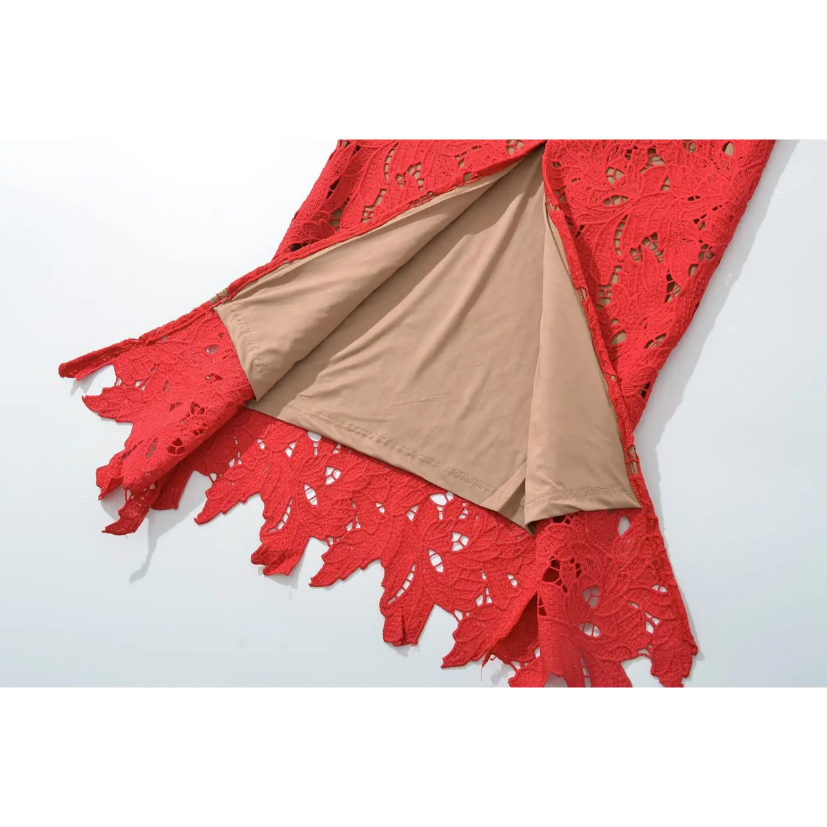 Close‑up of beige inner lining under red outer lace fabric