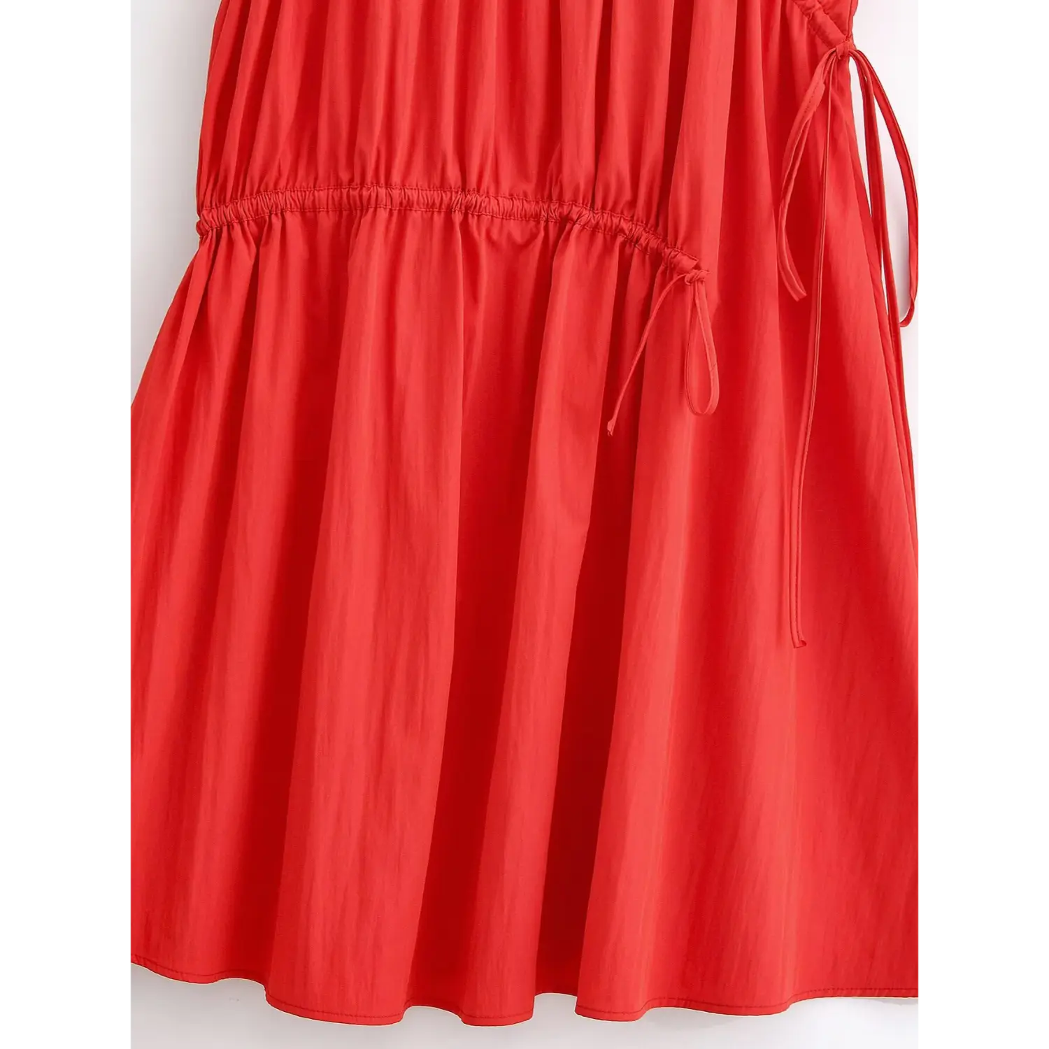 Partial close‑up of side drawstring and tiered ruffle seam detail