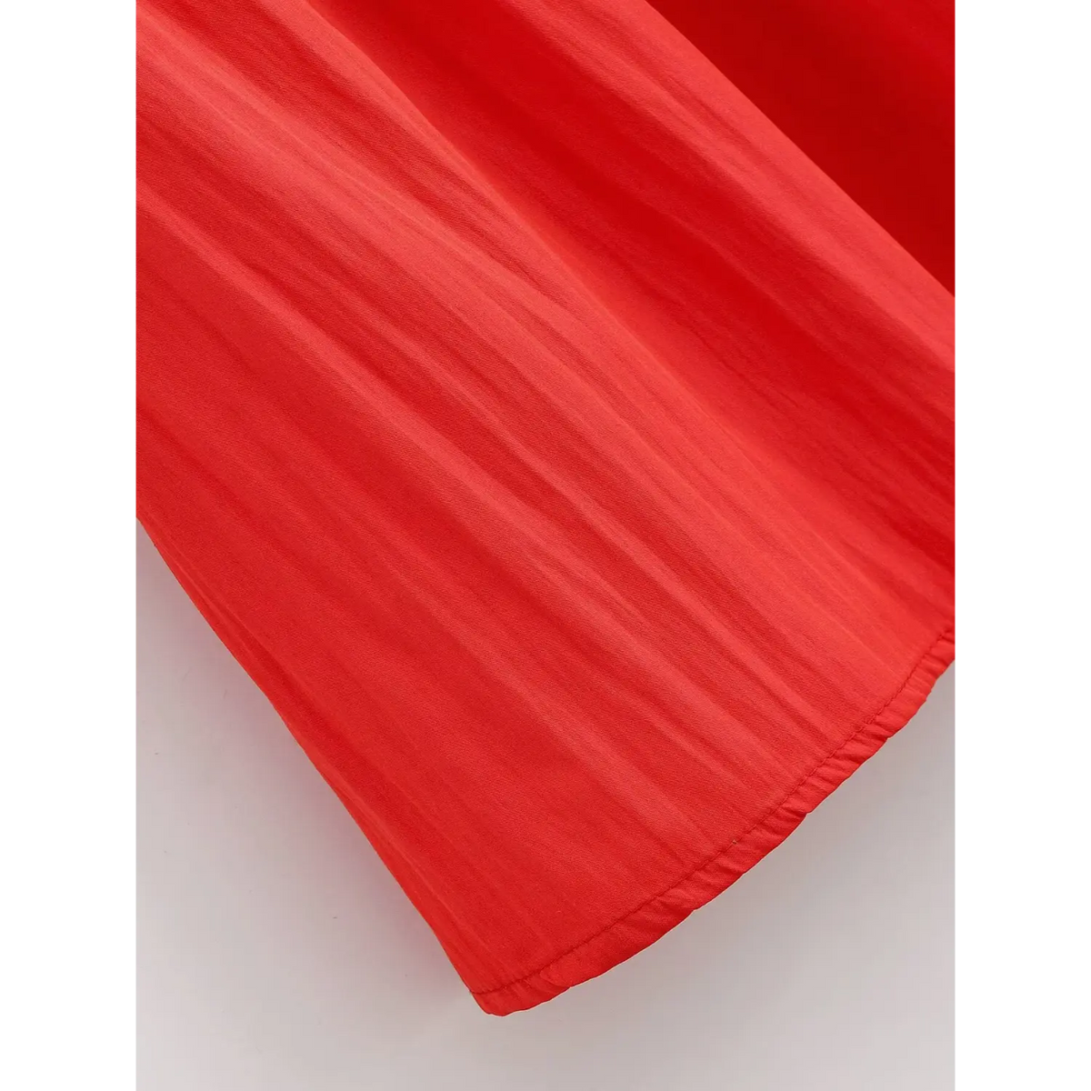 Close‑up of soft red flowy fabric and finished dress hem