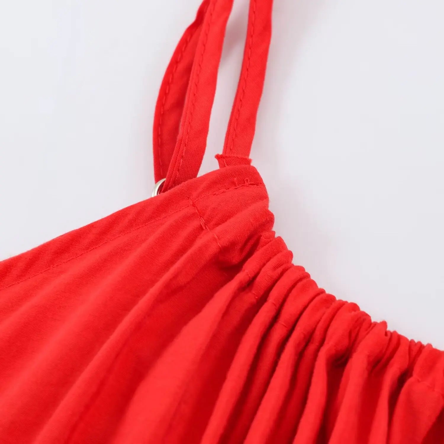 Close‑up of gathered fabric at spaghetti strap shoulder