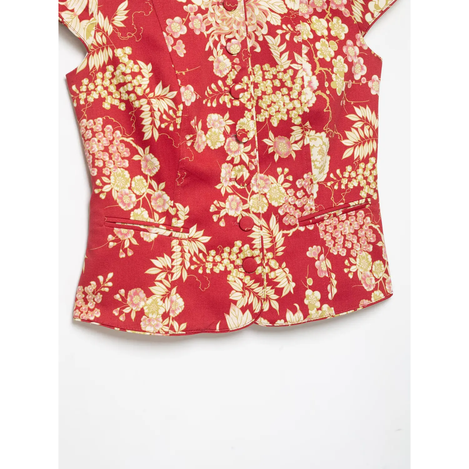 Flat lay lower view showing bottom button placket, side pockets and curved hem of red chinese floral short jacket