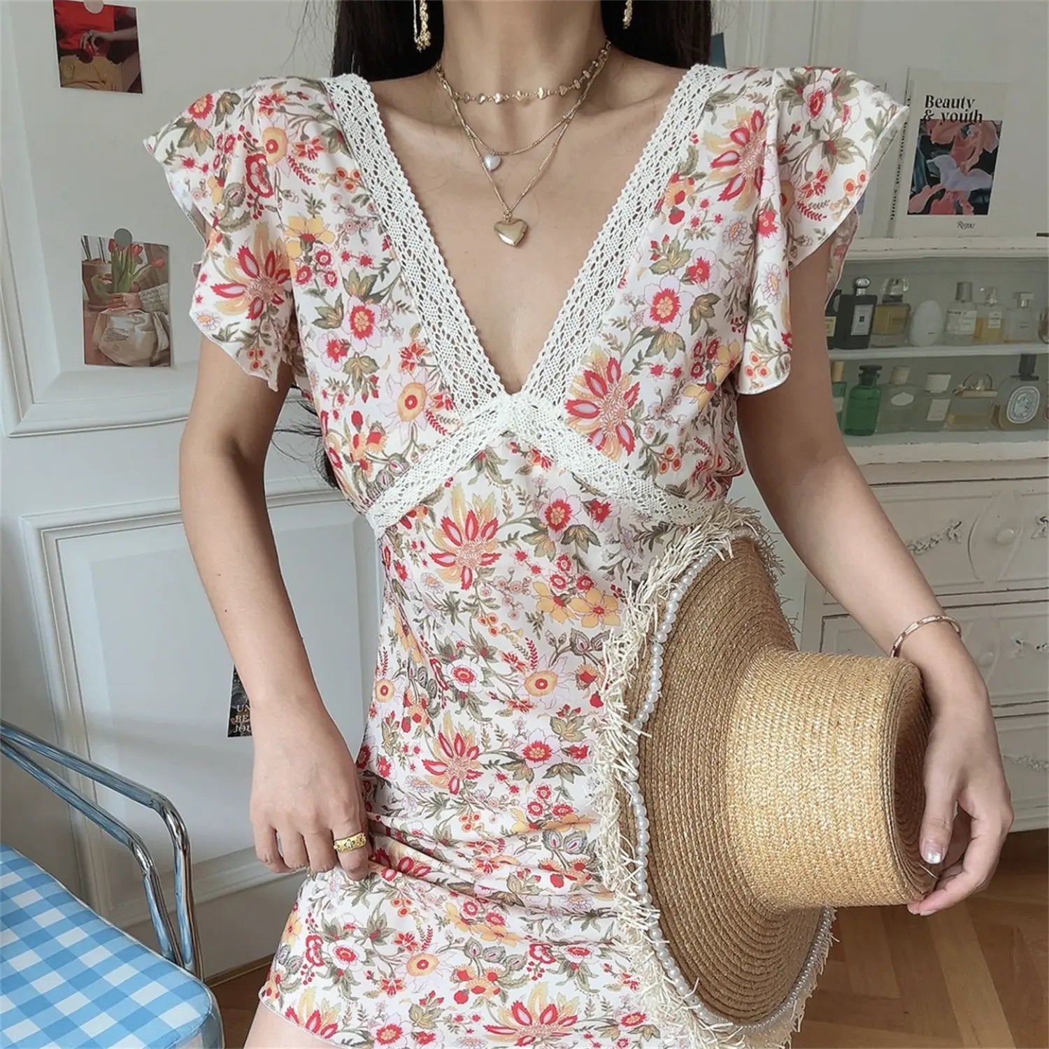 Outfit lifestyle photo vintage floral lace wrap mini dress, holding straw bucket hat, ruffle sleeve summer vacation women sundress