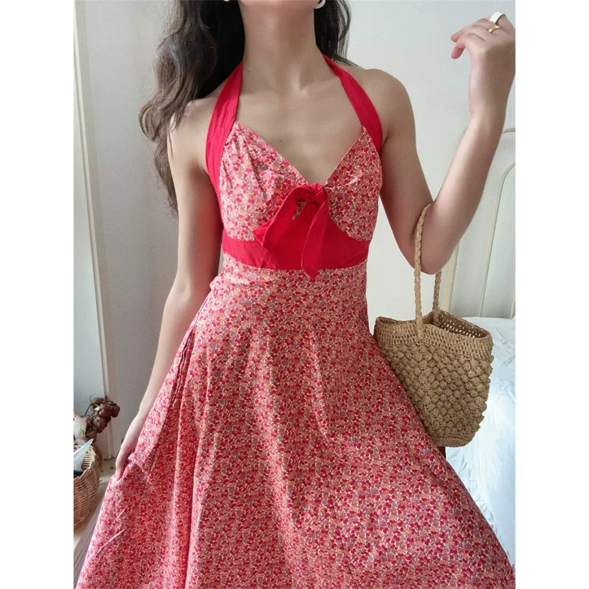 Close front lifestyle shot of vintage cherry floral halter maxi dress paired with rattan woven handbag, classic picnic summer outfit.