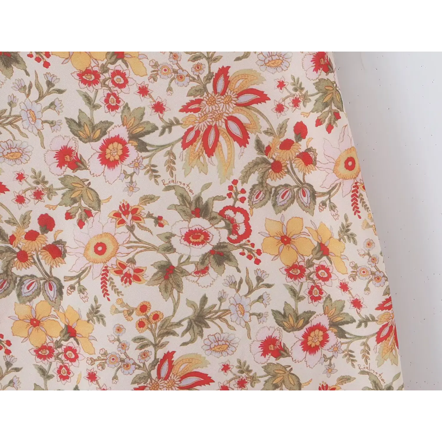 Macro fabric shot vintage mixed wildflower print, red yellow orange blooms green leaves on cream base lightweight woven textile