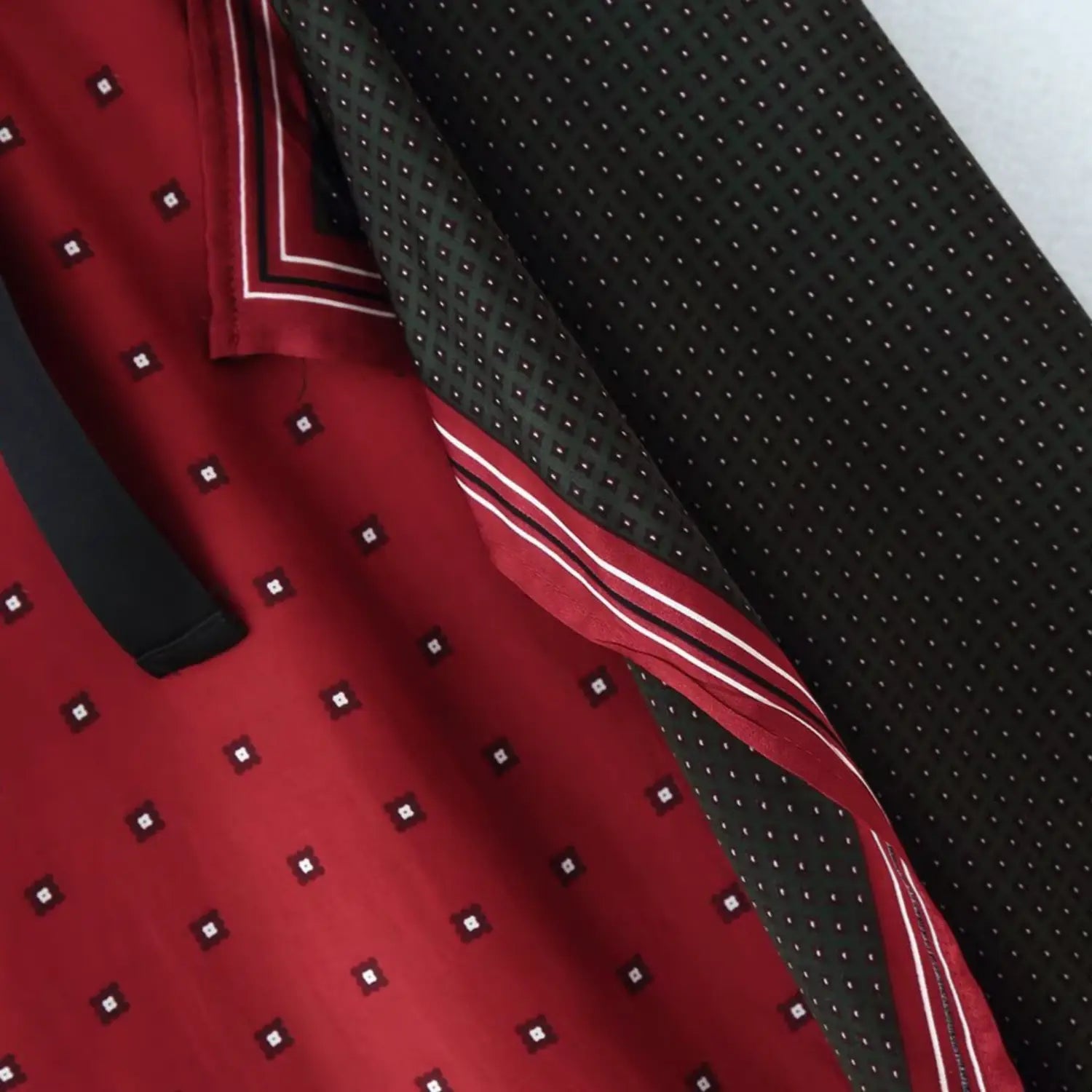 Side overlap close-up showing both red square dot fabric and black micro dot fabric with finished piping edging