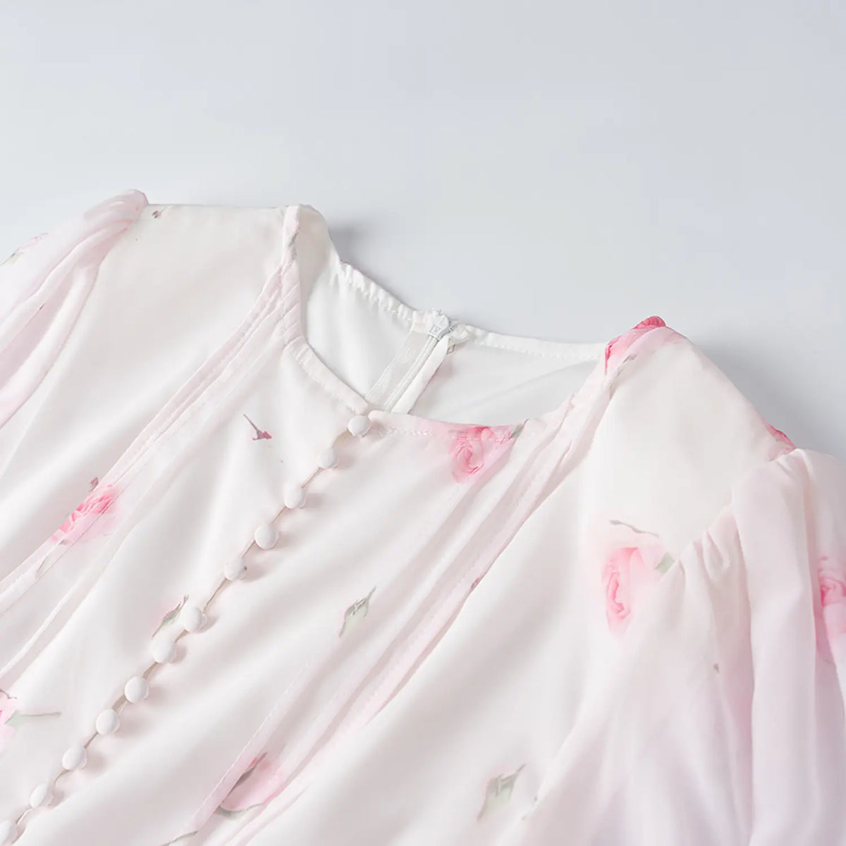 Close-up of round neck, button placket and back zipper