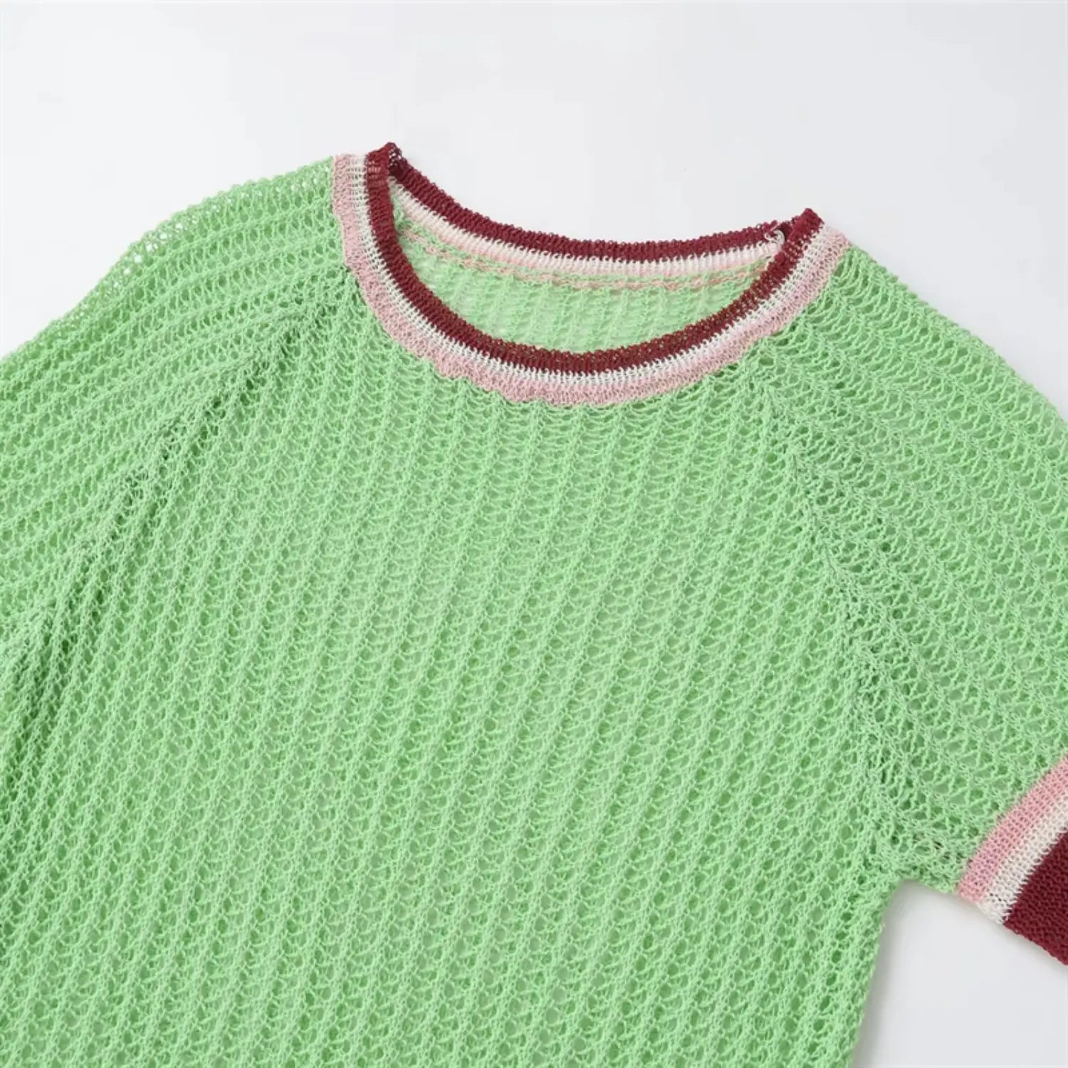 Upper torso close-up, round ribbed neckline, raglan shoulder seams, short sleeve cuffs with pink, white and burgundy stripe trim
